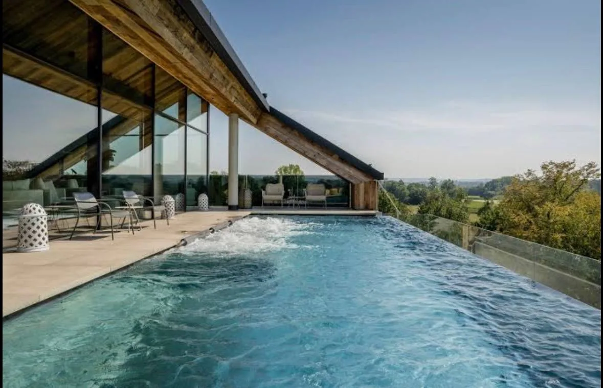Infinity-Pool unter dem Holzdach des Hotels