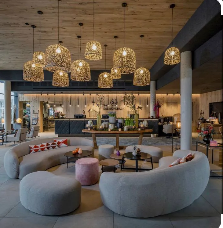Lobby mit runden Sofas und geflochtenen Leuchten