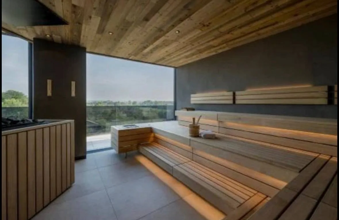 Sauna aus hellem Holz mit Panoramafenster